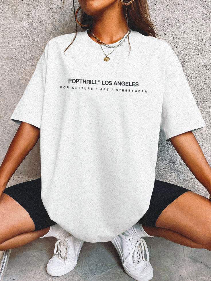 A female model wearing an oversized fit graphic tee with the Popthrill brand across the chest.